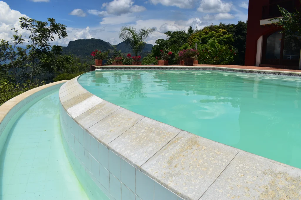 Piscina con agua color turquesa, con vista hacia un paisaje antioqueño. La piscina fue creada por Bluespace Piscina