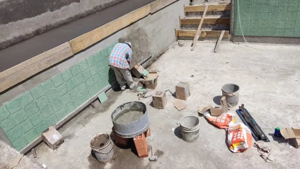 Persona reparando hasta el último detalle en una remodelación de una piscinas con vista a Medellín hecha por Bluespace